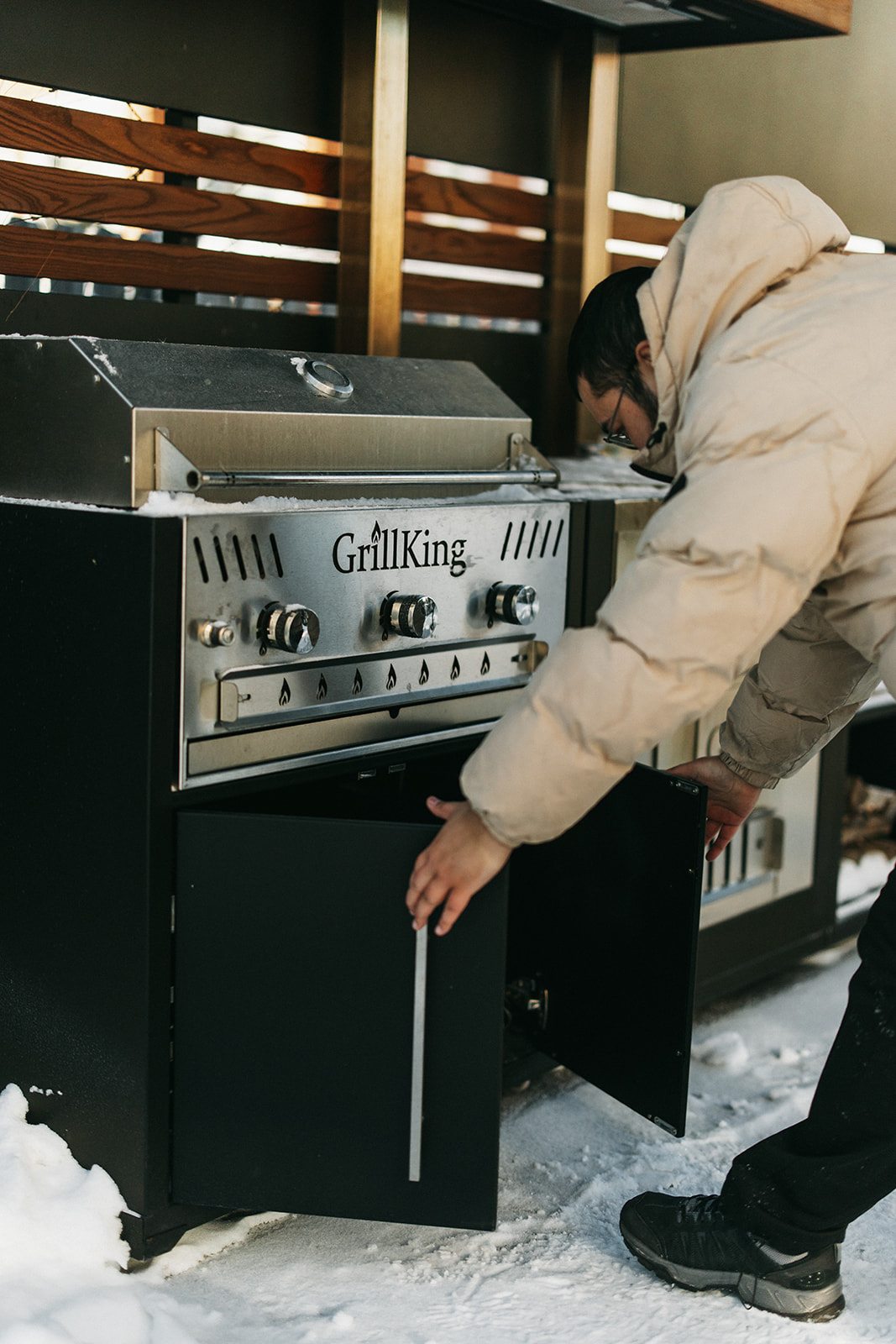 Монтажник GrillKing устанавливает модуль кухни зимой