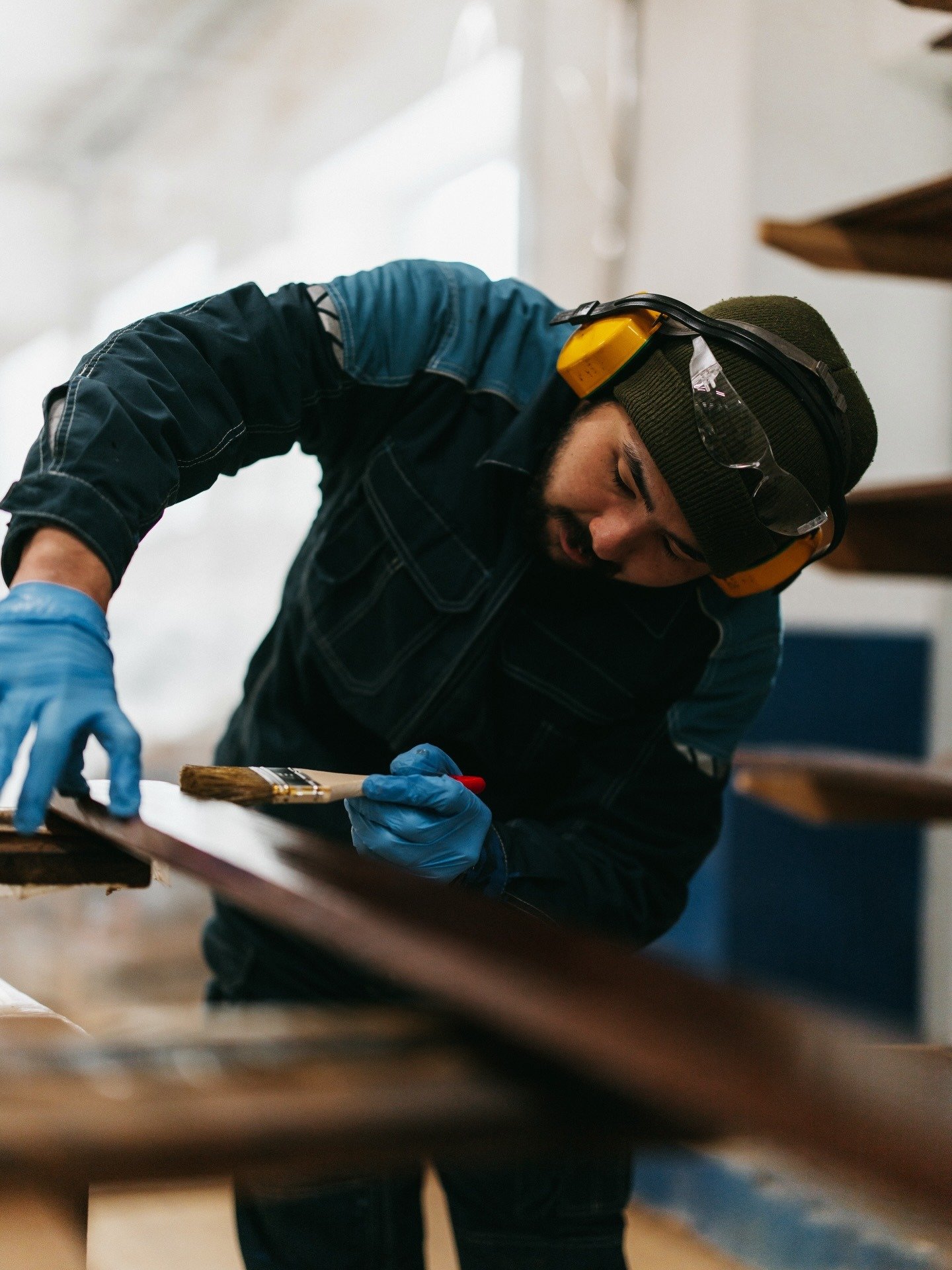 A craftsman oiling the end grain of a board by hand