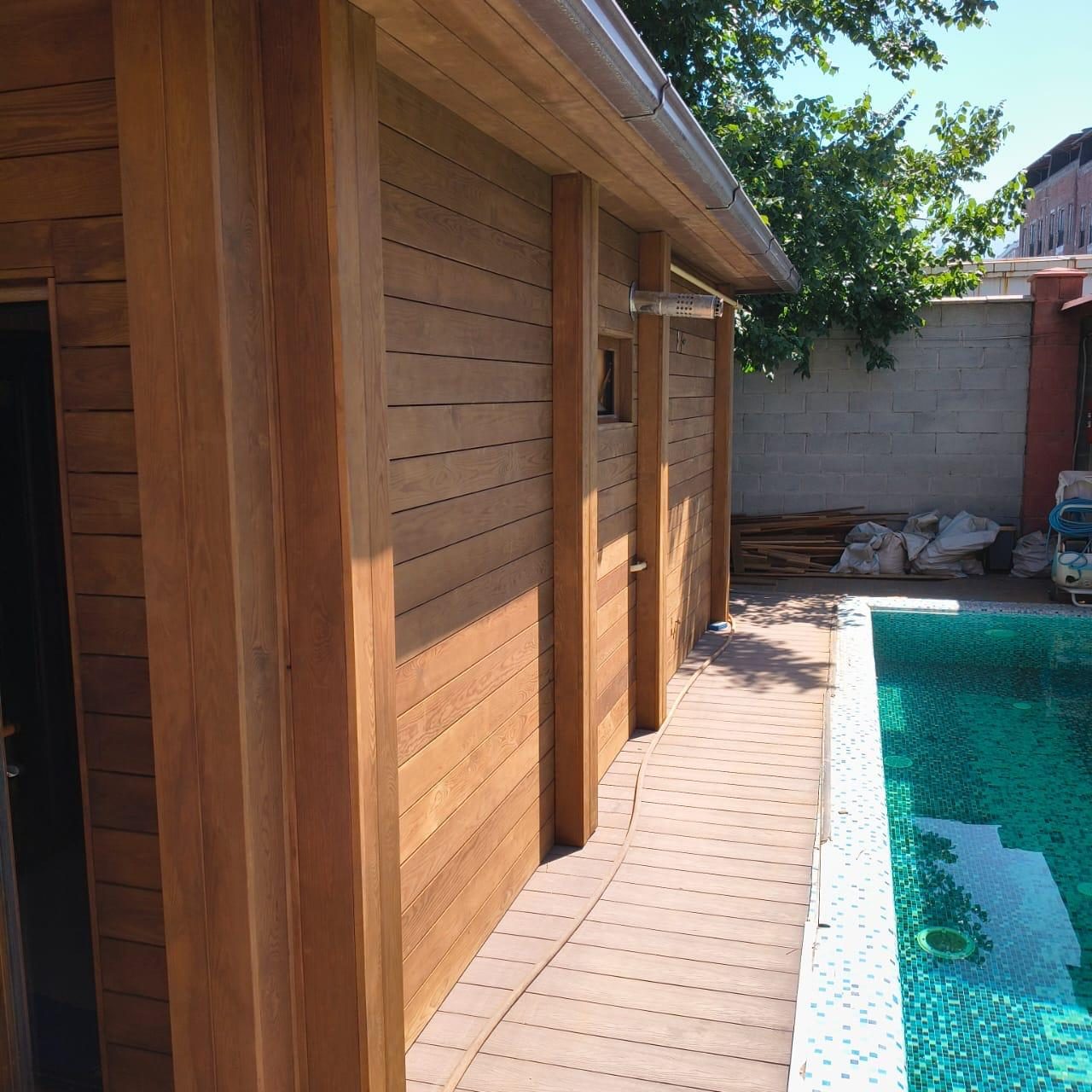 A thermo-karagach facade and deck beside a pool