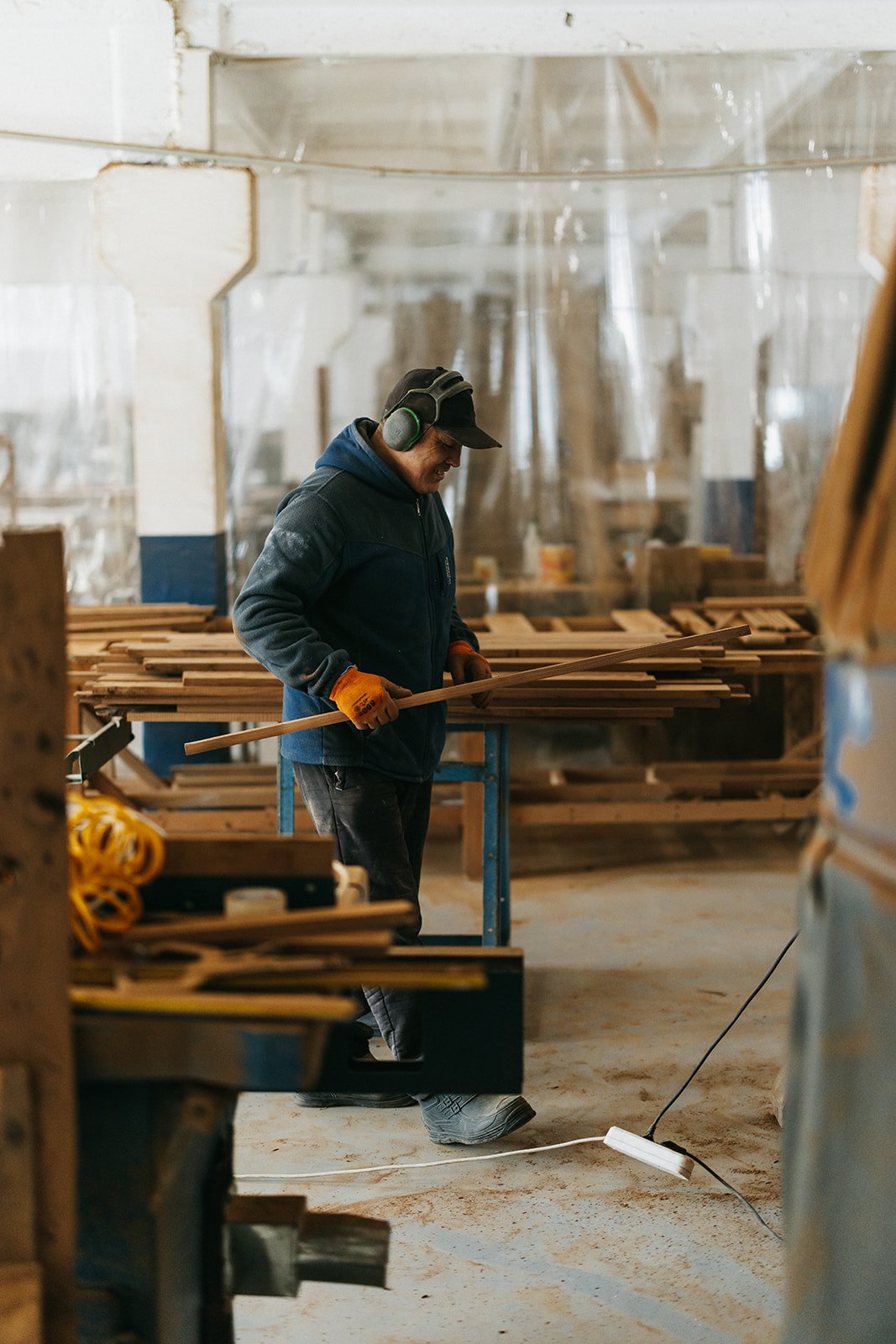 Столяр WoodPower отбирает термодоску у стеллажа в цехе